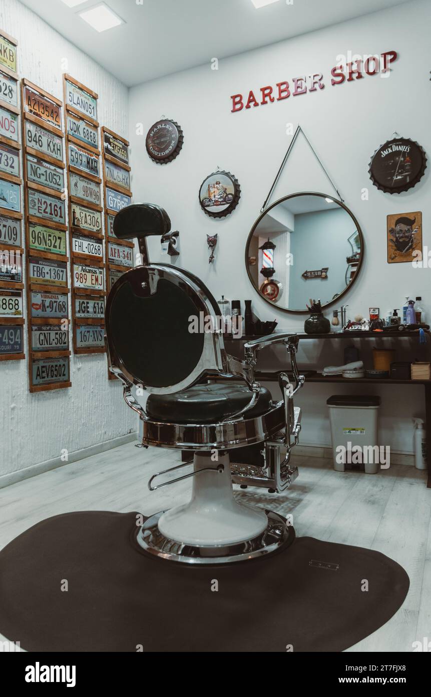 Un salon de coiffure animé avec un miroir circulaire orné d'un cadre élégant au premier plan Banque D'Images