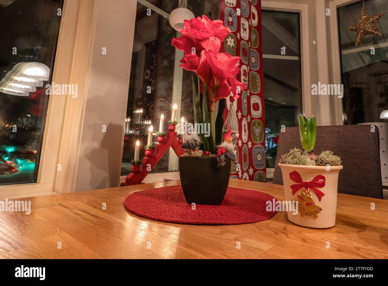 Salle à manger traditionnelle suédoise décorée de Noël avec table à mettre pour le réveillon de Noël. Lumières, rideaux, petites figurines du Père Noël. Gros plan phot Banque D'Images