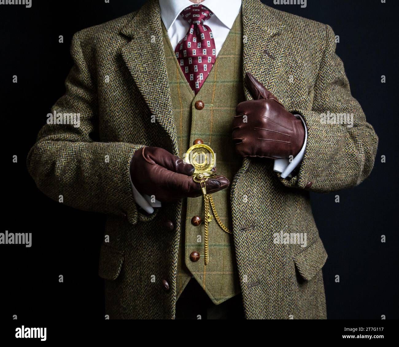 Portrait d'élégant gentleman anglais en tweed costume et gants en cuir tenant la montre de poche. Style vintage et mode rétro. Banque D'Images