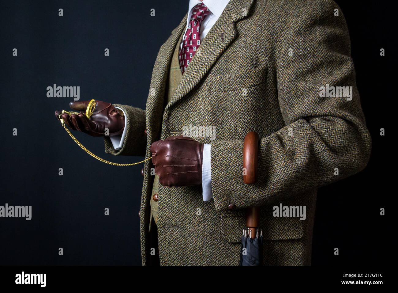 Portrait d'élégant gentleman anglais en tweed costume et gants en cuir tenant la montre de poche. Style vintage et mode rétro. Banque D'Images