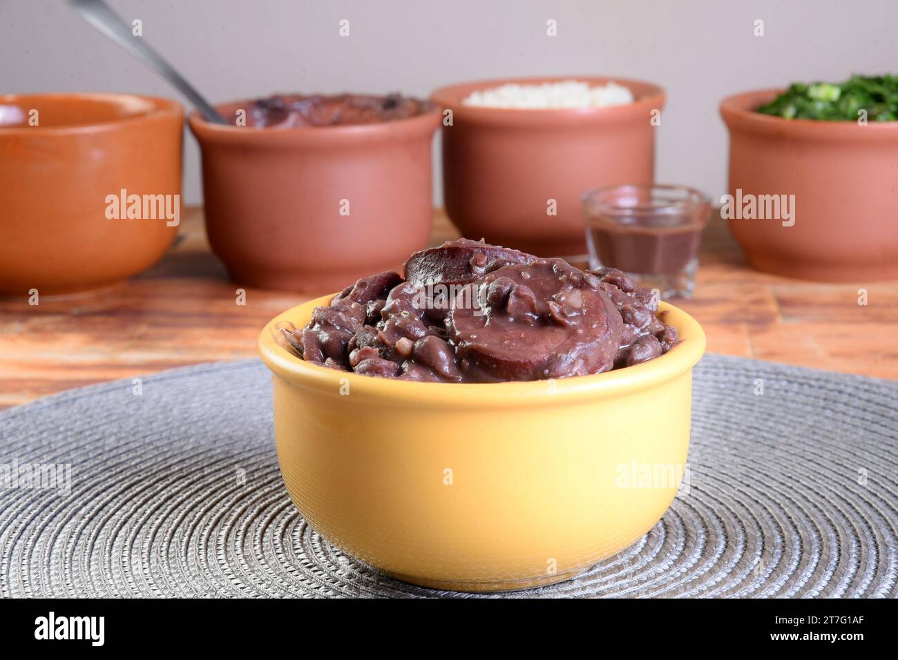 Cuisine brésilienne typique feijoada à base de haricots, porc, bacon, saucisse au chou, riz, salade, épices et poivre. Banque D'Images