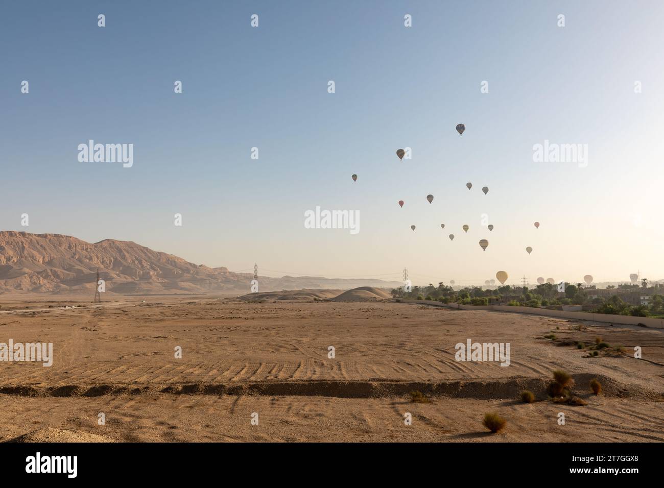 Groupe de montgolfières décollant dans le paysage désertique aride de la Vallée des Rois Banque D'Images