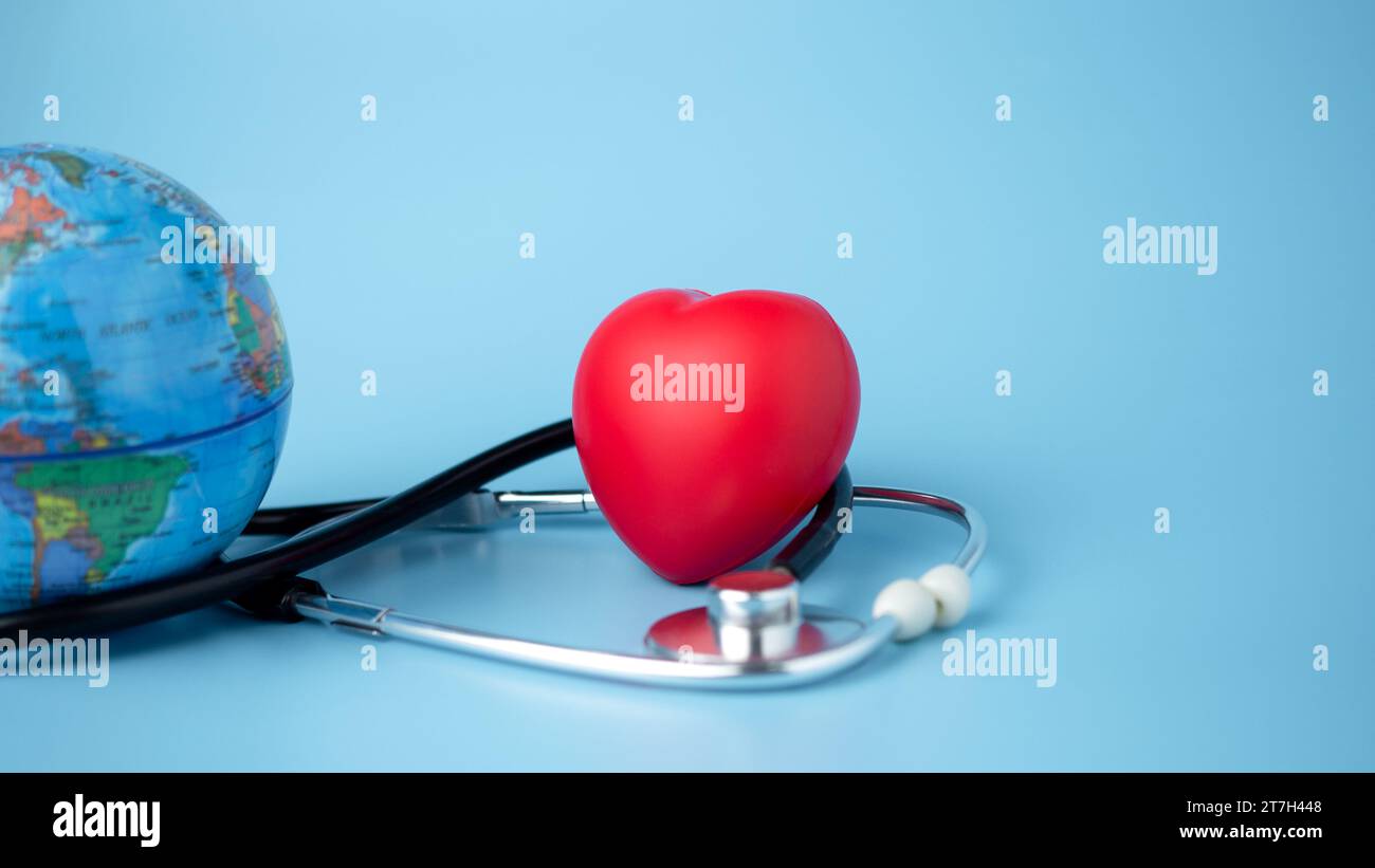 Concept d'assurance maladie et de bien-être médical, globe modèle et cœur rouge avec stéthoscope sur fond bleu, assurance santé et accès à la santéc Banque D'Images