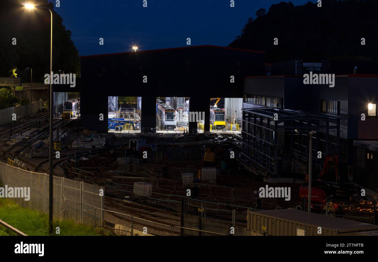 Dépôt de puits de Taff, Galles du Sud, Royaume-Uni Nouveau dépôt de tramway en construction pour le métro du sud du pays de Galles avec de nouveaux trains de tramway Stadler à l'intérieur la nuit. Banque D'Images