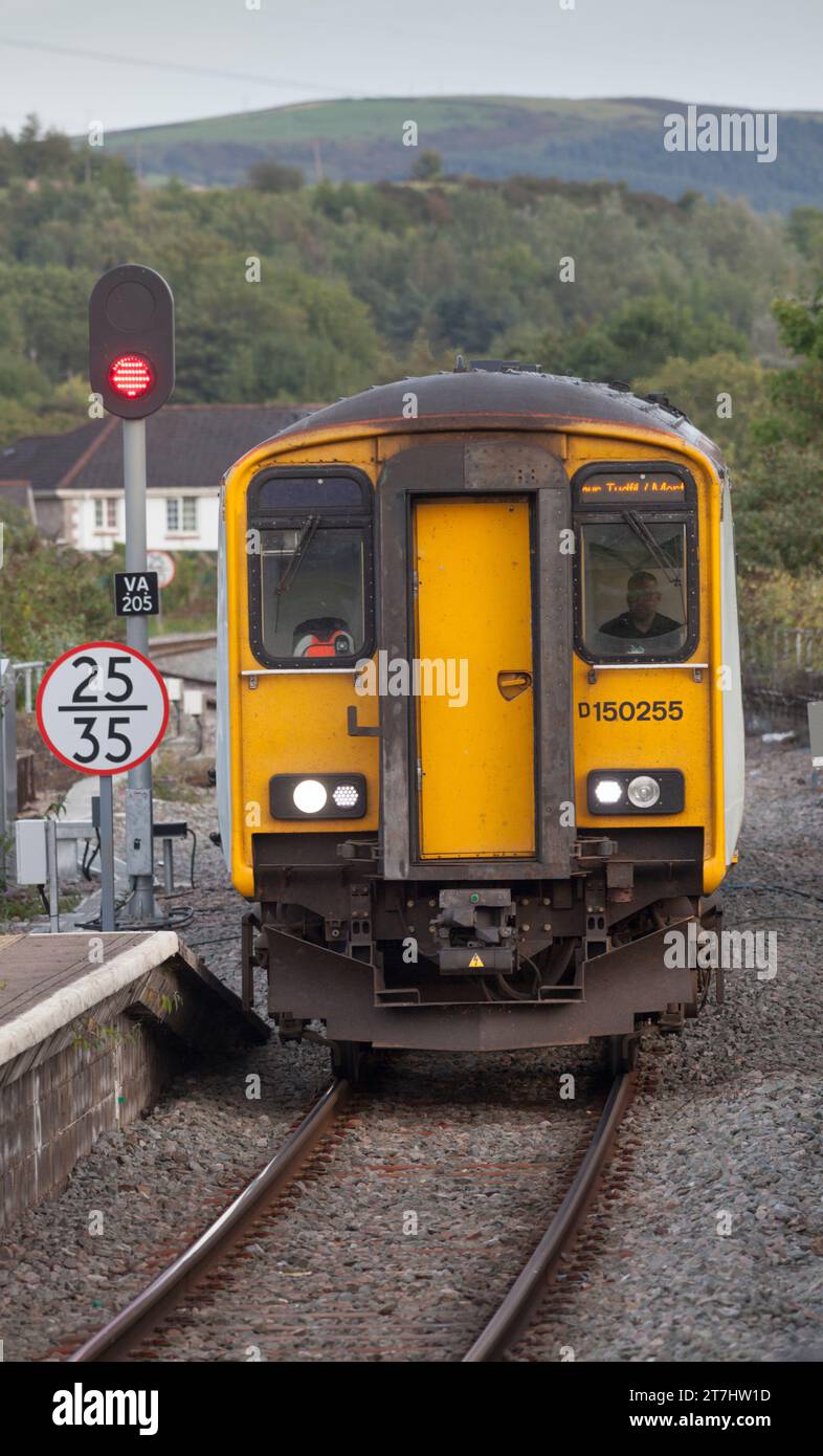 Transport pour le pays de Galles classe 150 Diesel train à unités multiples arrivant à Merthyr Tydfil, au sud du pays de Galles, au Royaume-Uni avec un signal ferroviaire LED rouge Banque D'Images