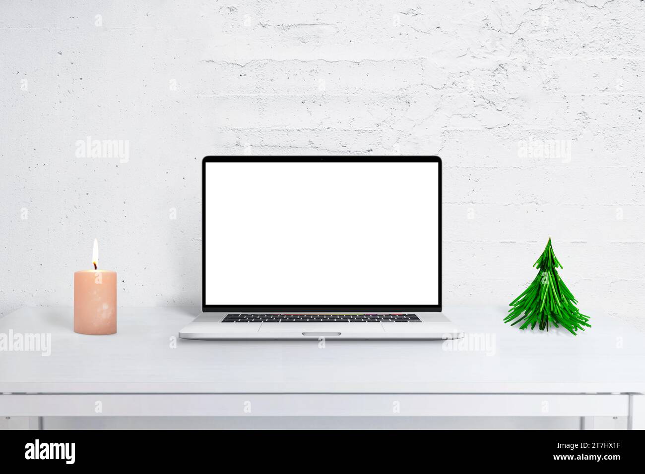 Maquette d'ordinateur portable sur le bureau avec décor de Noël, arbre et calendrier. Lieu de bureau de vacances confortable pour les salutations saisonnières et la productivité. Banque D'Images