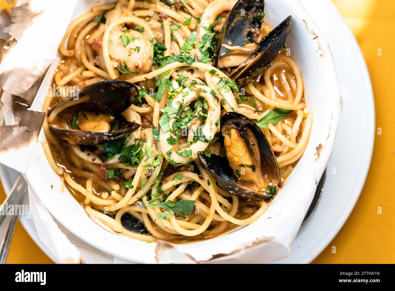 Un bol de spaghetti et de moules dans une sauce blanche crémeuse sur une table Banque D'Images