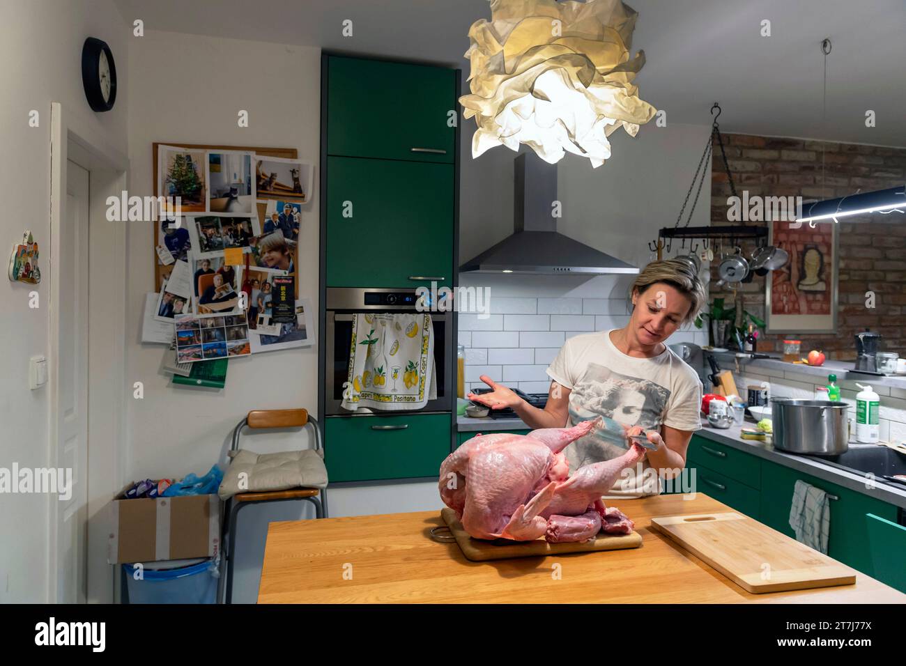 Femme d'âge moyen dans la cuisine à la maison préparant la grande dinde pour le dîner de Thanksgiving Banque D'Images