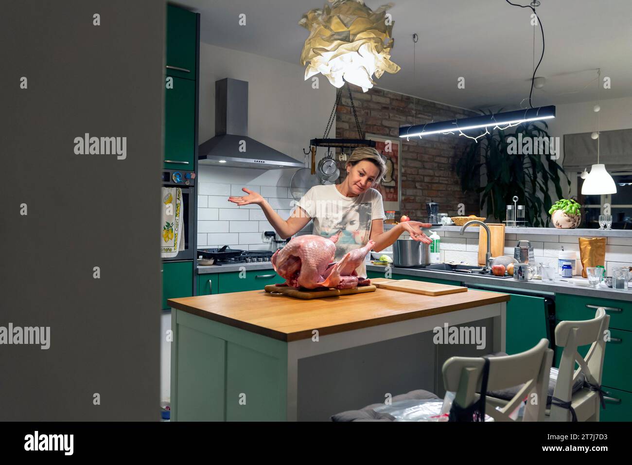 Femme d'âge moyen dans la cuisine à la maison préparant la grande dinde pour le dîner de Thanksgiving Banque D'Images