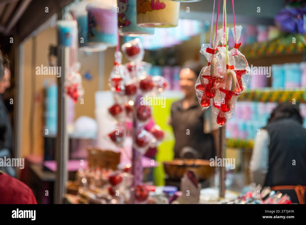 Capturez la douceur de la saison : les sucettes de bonbons éclatantes occupent le devant de la scène lors de la foire de Noël festive, tentant avec des délices sucrés pour holida Banque D'Images