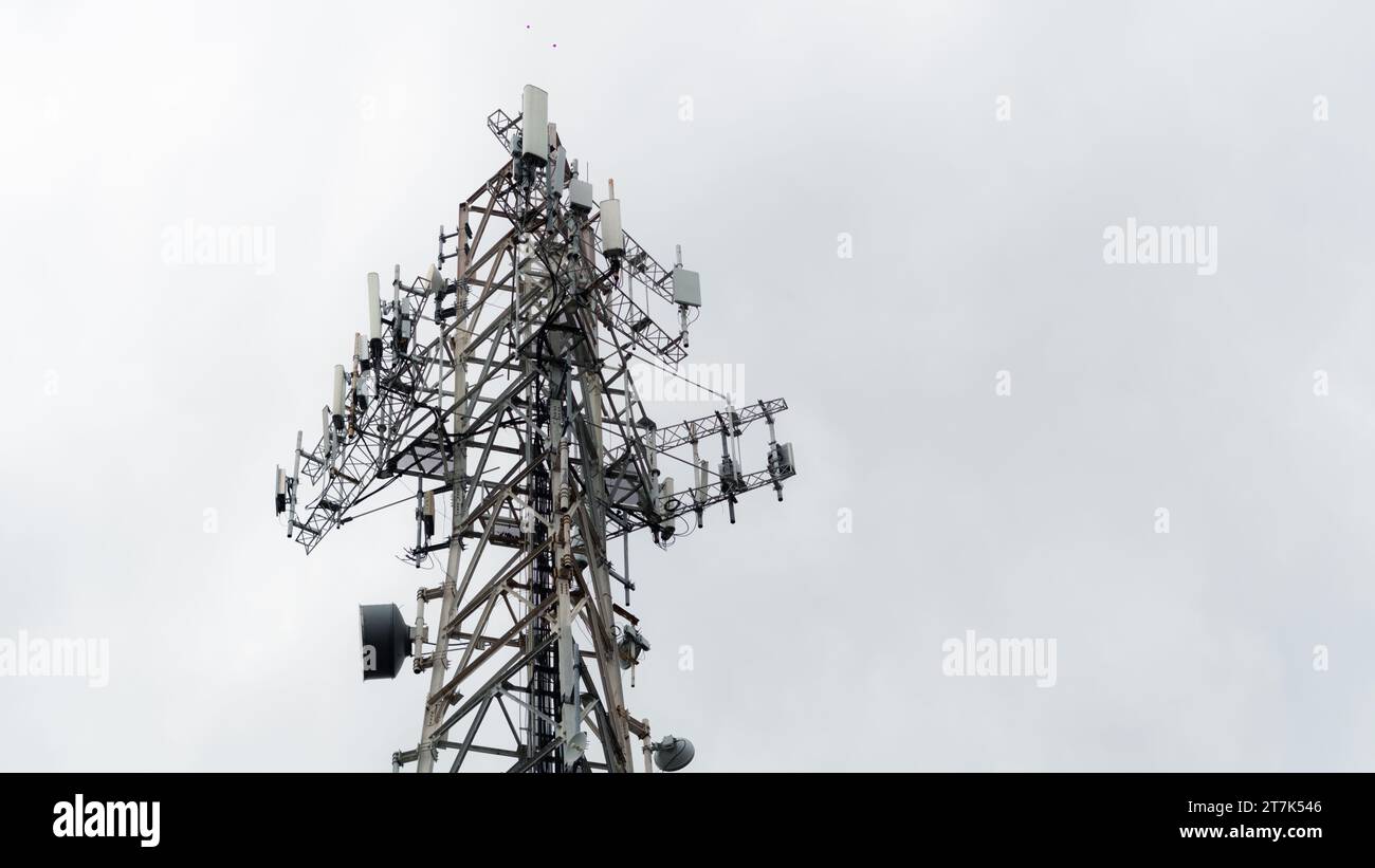 Une vue majestueuse d'une ancienne tour radio illuminée sur un ciel bleu clair, parfaite pour les concepts de téléphonie mobile et de communication de l'industrie Banque D'Images