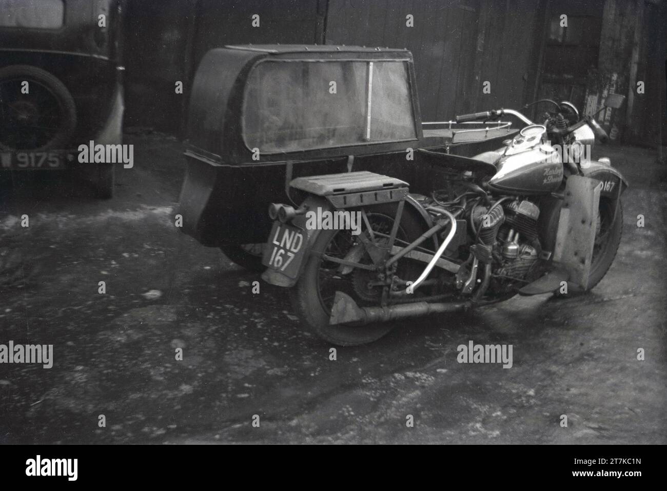 Années 1950, historique, une moto Harley Davidson avec side-car garée dans une allée latérale, Oldham, Angleterre, Royaume-Uni. Le side-car à une roue et la moto à deux roues font un véhicule à trois roues et est parfois connu sous le nom de combinaton, tenue ou gréement. Banque D'Images