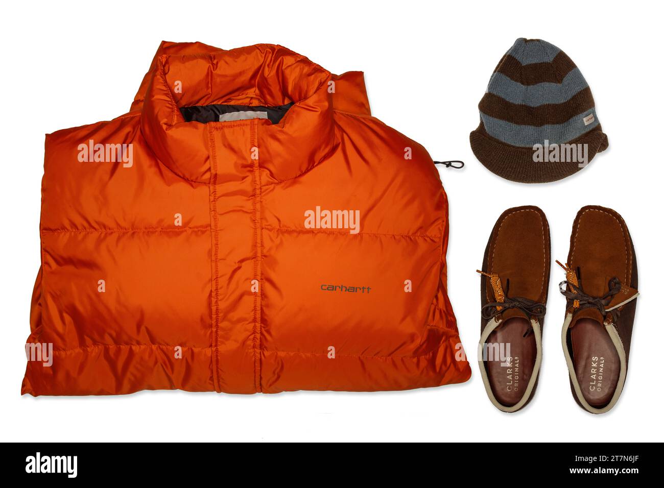 Une superbe vue de dessus haute résolution d'une veste en duvet orange Carhartt tendance streetwear et d'un bonnet en laine rayée et de Clarks Originals Walabees Banque D'Images