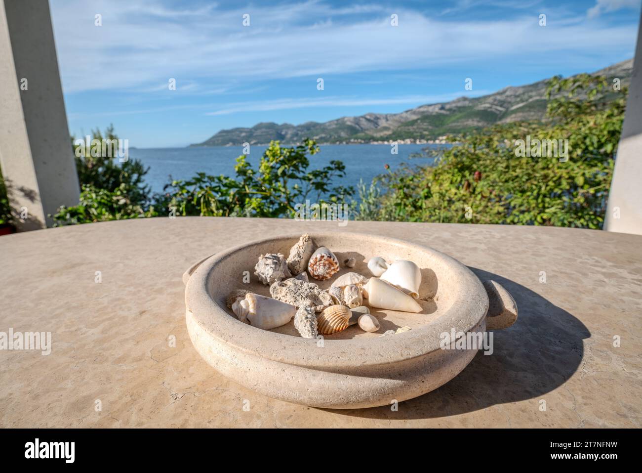 Plateau décoratif en pierre avec coquillages sur une table de terrasse donnant sur la mer Banque D'Images