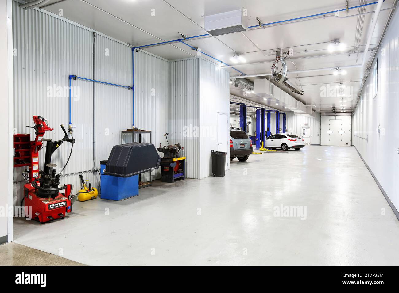 La baie de service avec équilibreurs de roues et ascenseurs hydrauliques, dans un atelier de réparation automobile propre, neuf, moderne Banque D'Images