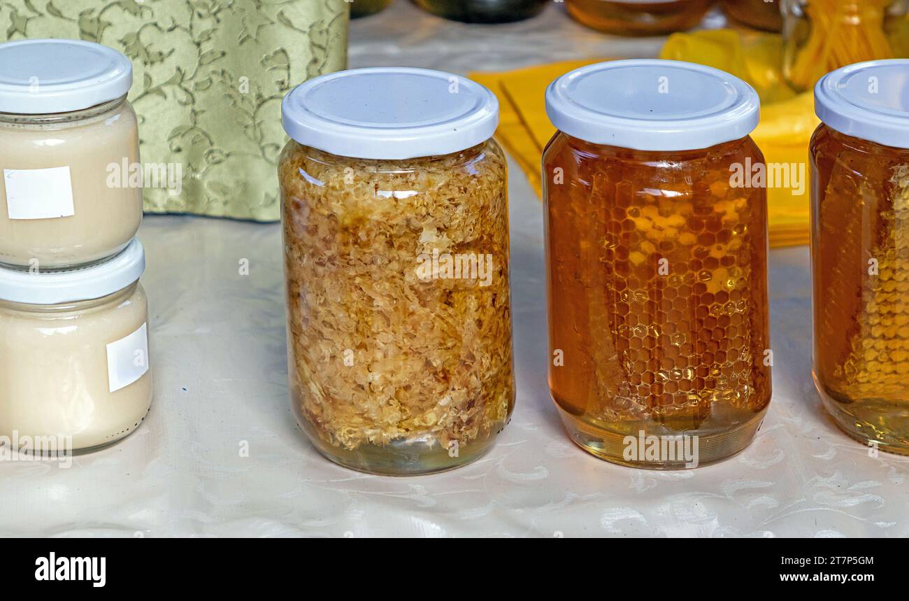 Peigne de miel de gelée royale et autres produits d'abeille dans des bocaux en verre vendus sur l'étal du marché Banque D'Images