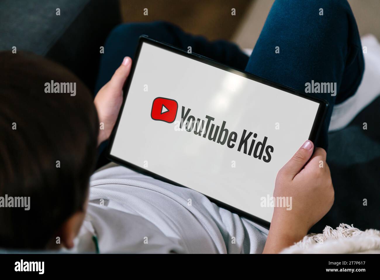 Petit garçon d'école à l'aide d'une tablette avec youtube enfants logotype à l'écran. Rosario, Argentine - 16 novembre 2023 Banque D'Images