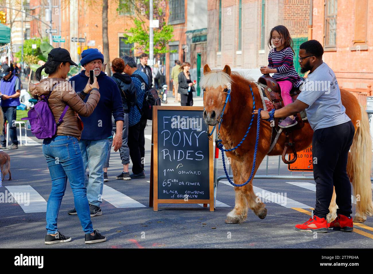 Les Black Cowboys de Brooklyn proposent des promenades à poney aux enfants lors de la Journée de la Terre sans voiture 2022 le long de l'Avenue B dans East Village de Manhattan, New York. Banque D'Images
