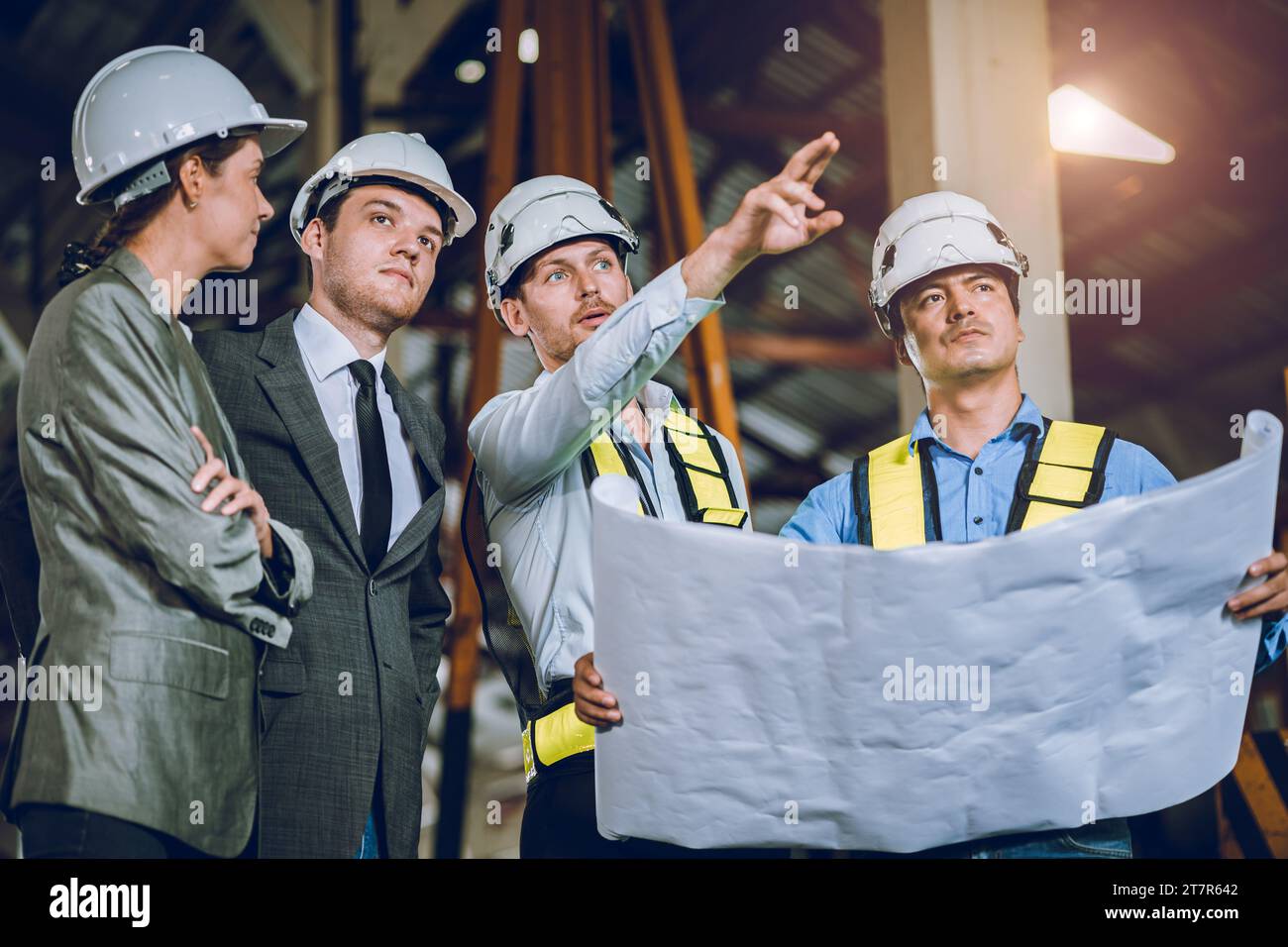 réunion des investisseurs d'affaires avec l'équipe d'ingénieurs avec le plan d'étage imprimé bleu regardant l'étude sur le site de construction. Banque D'Images