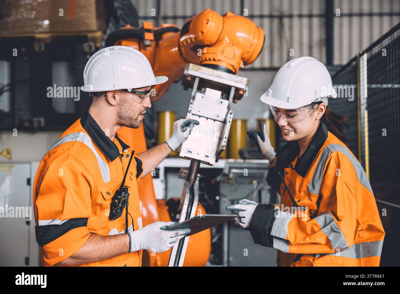 L'équipe d'ingénieurs assure le service de soudage des robots travaillant dans l'usine d'automatisation. Les personnes travaillant en costume de sécurité travaillent robotique ARM logiciel de programmation ou de remplacement par Banque D'Images