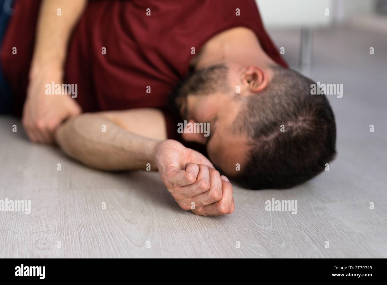 Homme inconscient allongé sur le sol dans un accident d'épilepsie dans une chambre Banque D'Images