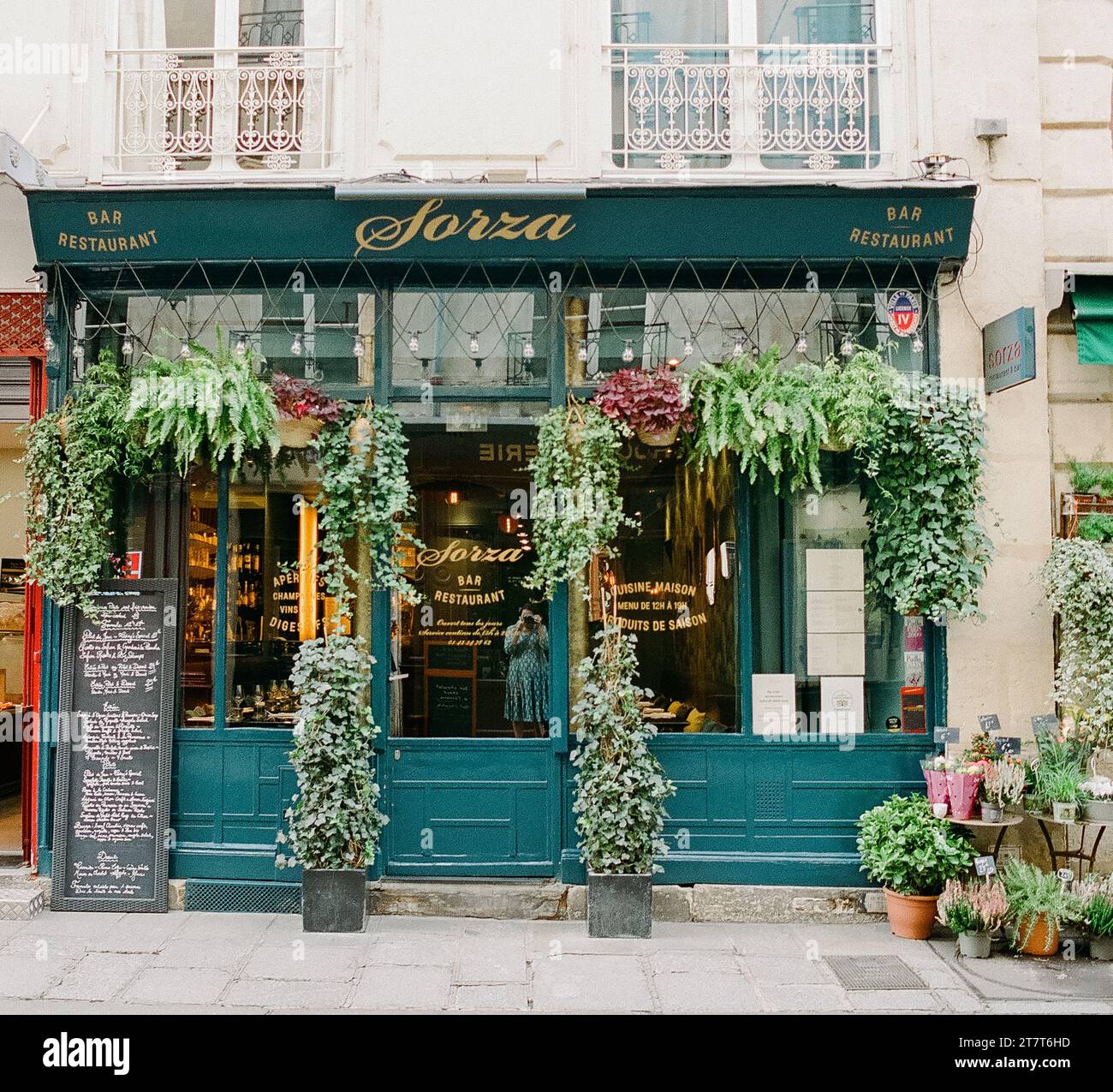 Façade verte de magasin couverte de plantes luxuriantes à Paris France Banque D'Images