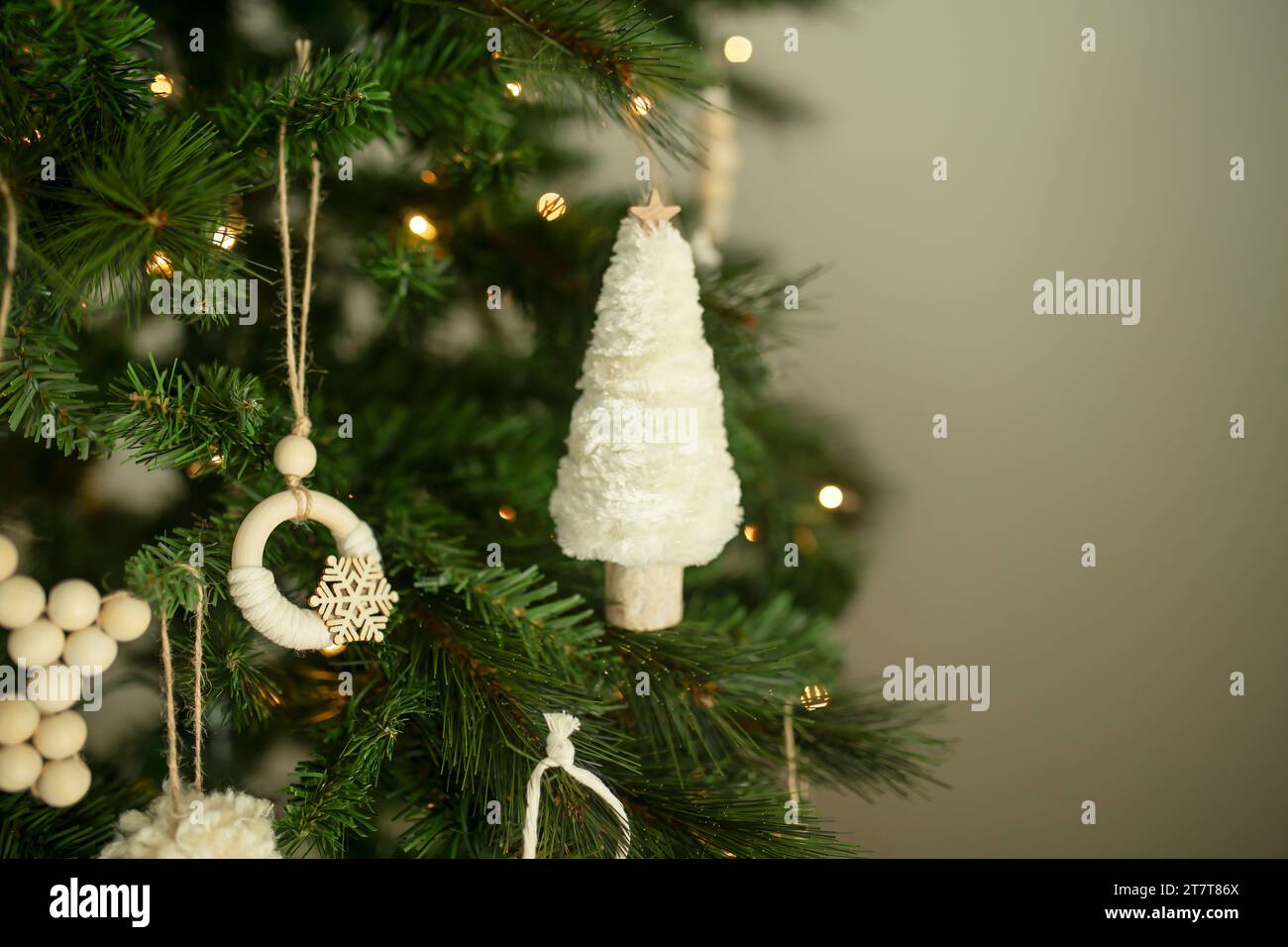 Ornements de noël blancs suspendus à un arbre avec des lumières blanches Banque D'Images