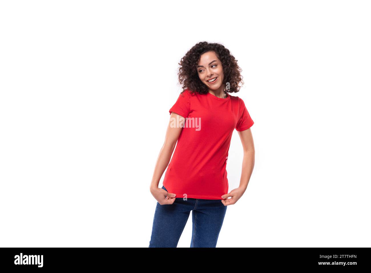 femme brune mince de 30 ans vêtue d'un t-shirt de base rouge sur un fond blanc avec espace copie Banque D'Images