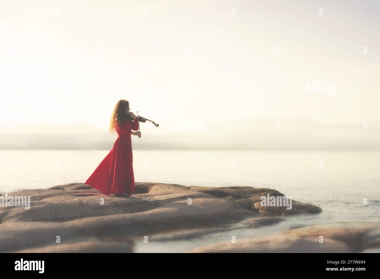 femme à la robe rouge joue du violon dans une atmosphère enchantée Banque D'Images