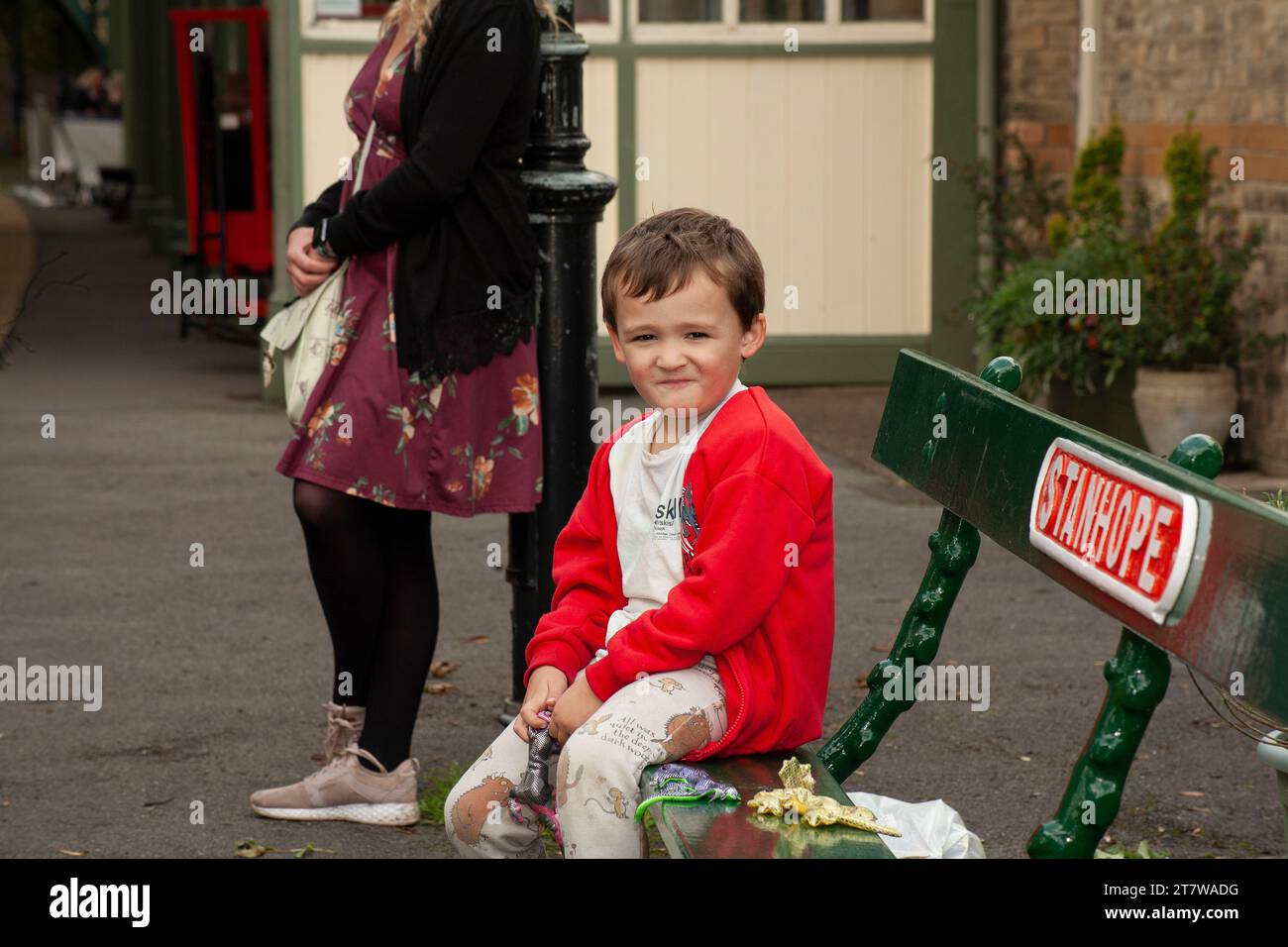 Une scène qui réchauffe le cœur se déroule alors qu’un garçon de 6 ans et sa mère célibataire attendent patiemment l’arrivée du train Banque D'Images