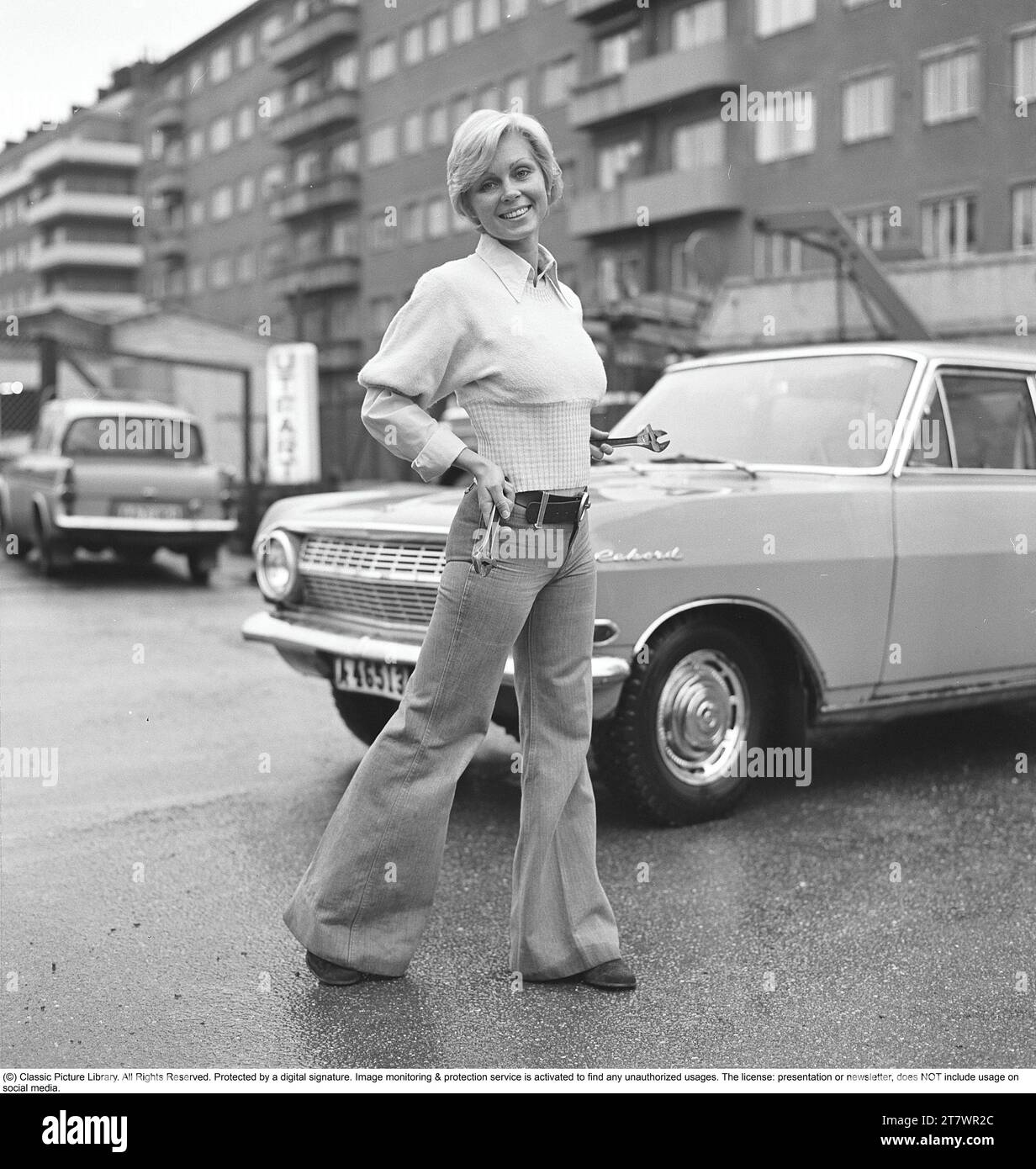 La mode des années 1970 Une jeune femme portant la mode typique des années 1970, un pantalon à jambes larges. Un style appelé Bell-bottols ou fares, pantalons qui s'élargissent des genoux et vers le bas, formant une forme de cloche de la jambe du pantalon. 1971. Kristoffersson réf. EF65 Banque D'Images