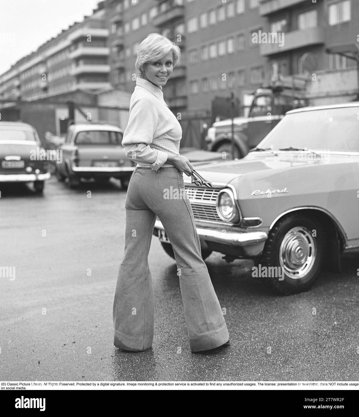 La mode des années 1970 Une jeune femme portant la mode typique des années 1970, un pantalon à jambes larges. Un style appelé Bell-bottols ou fares, pantalons qui s'élargissent des genoux et vers le bas, formant une forme de cloche de la jambe du pantalon. 1971. Kristoffersson réf. EF65 Banque D'Images