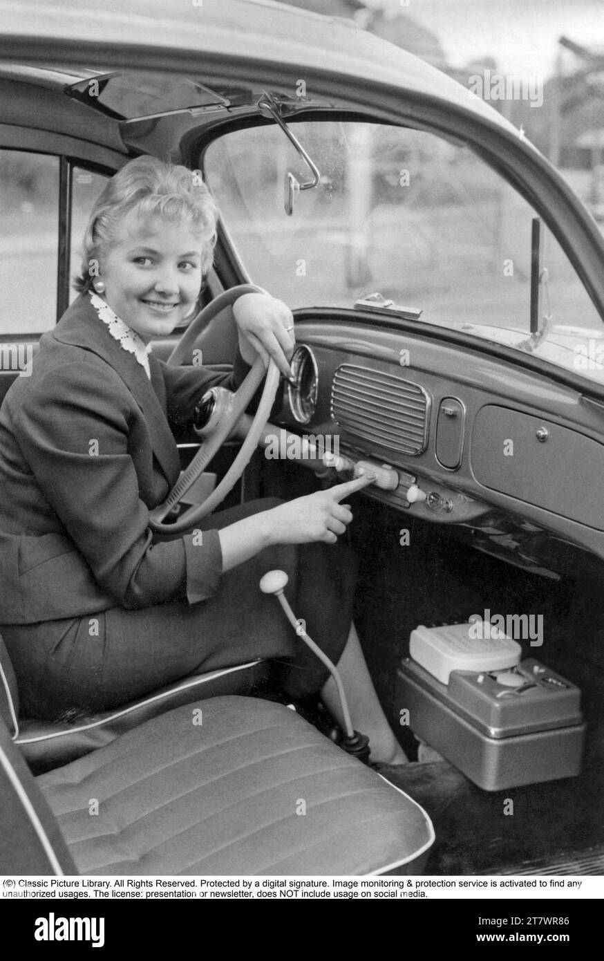 Dans Les Années 1950 Une Jeune Femme Dans Une Voiture Utilisant Certaines Des Fonctionnalités 