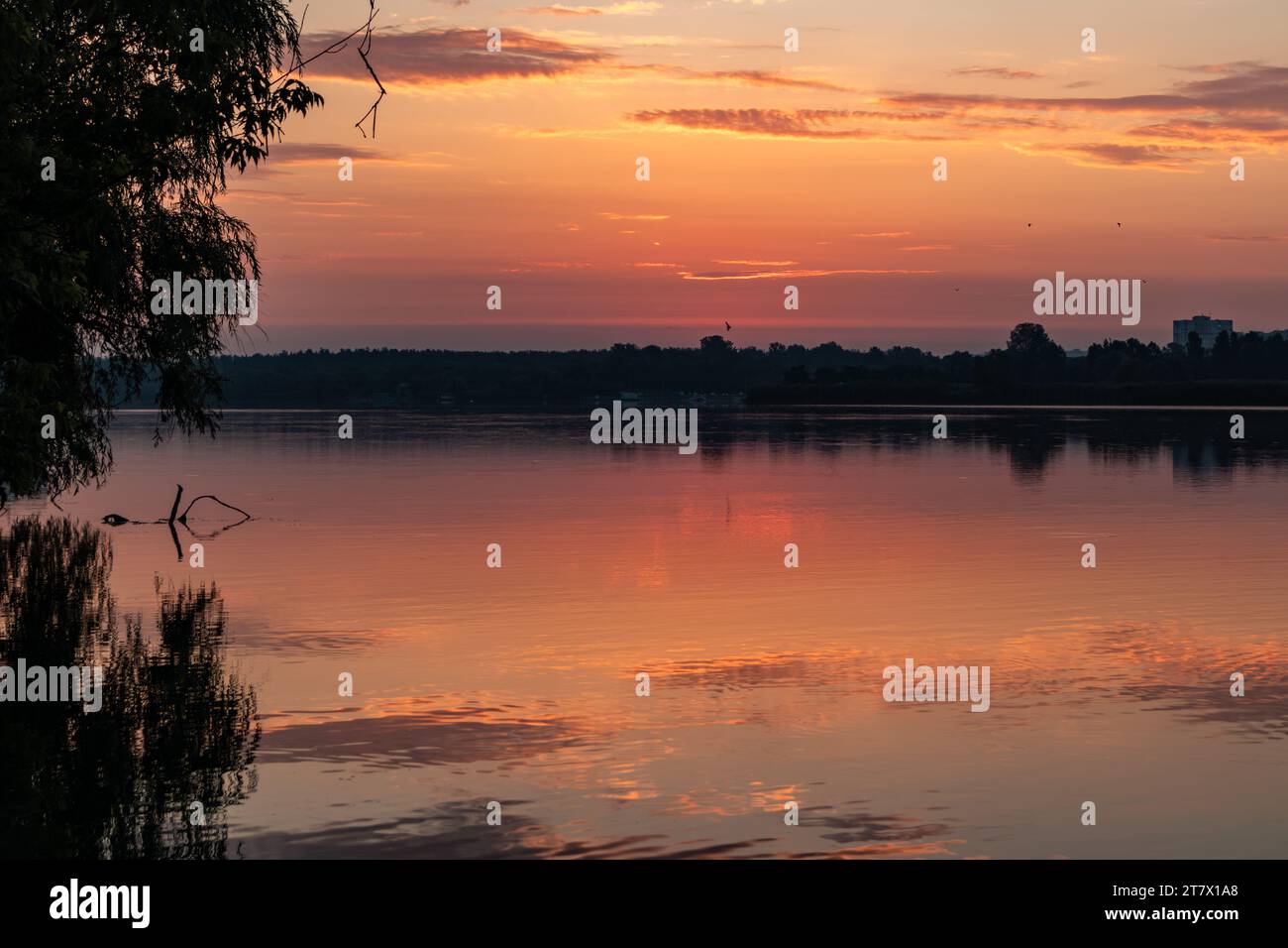 Ciel de lever du soleil sur le lac avec des nuages se reflétant dans la surface de l'eau miroir calme. Matin coloré au bord de la rivière Banque D'Images