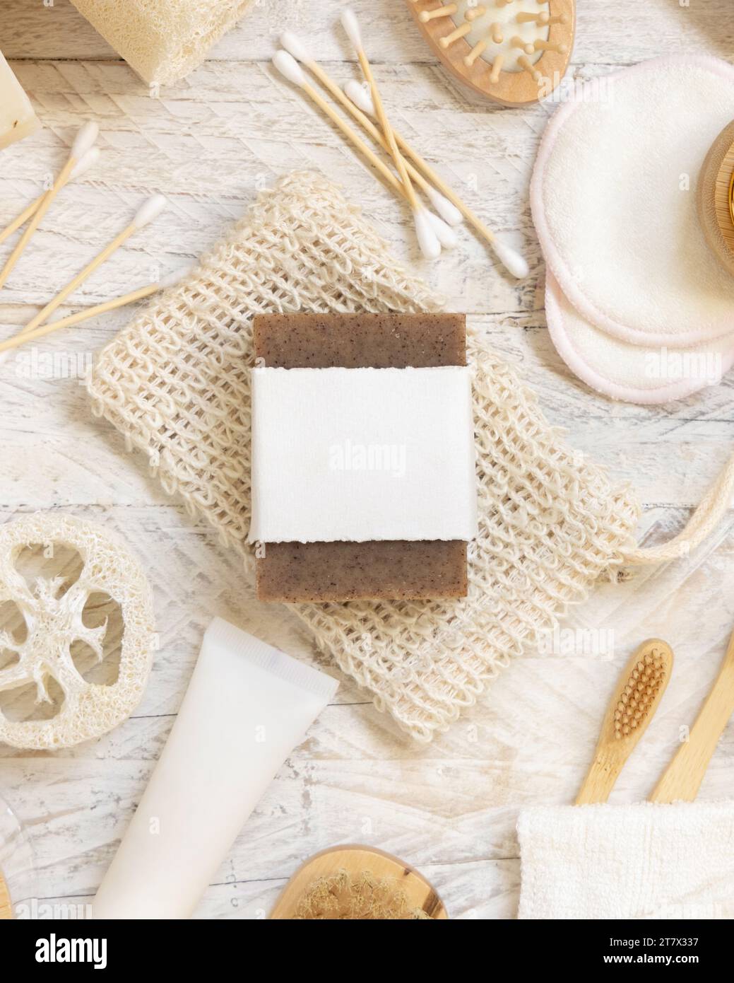 Pain de savon beige bio fait à la main avec étiquette vierge sur le sac économiseur de savon près de l'hygiène articles - éponges naturelles et brosse, brosses à dents en bambou et coton-tige Banque D'Images