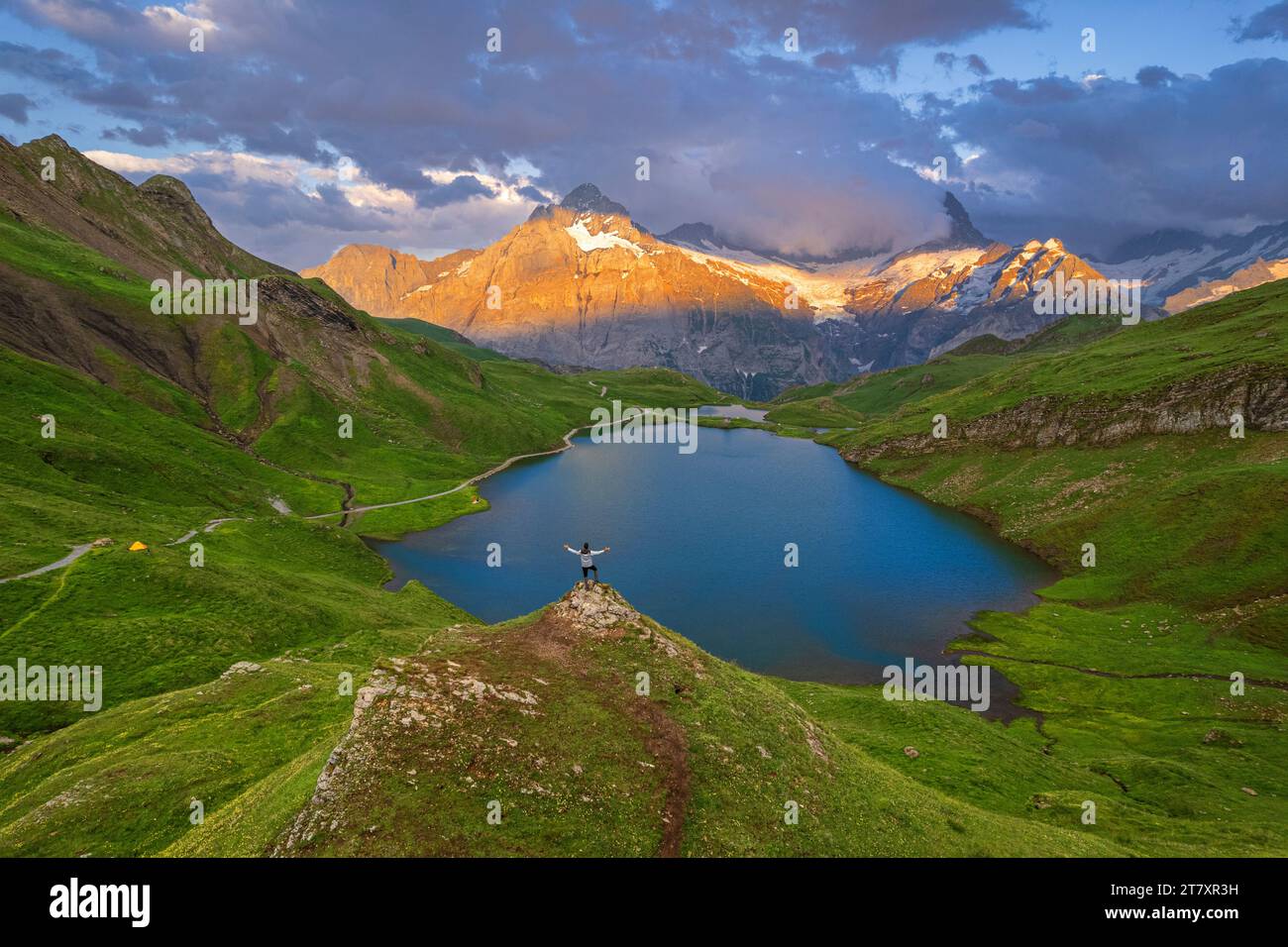 Joyeux randonneur surplombant Bachalpseee admirant le coucher de soleil sur les montagnes de l'Oberland bernois, Grindelwald, canton de Berne, Suisse, Europe Banque D'Images