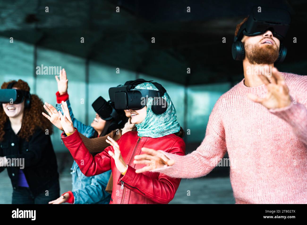 Jeunes amis multiraciaux utilisant des lunettes futuristes de réalité virtuelle - technologie et métaverse concept Banque D'Images