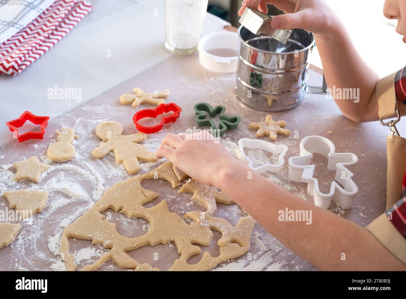 Les mains de maman et de fille coupent les biscuits de la pâte avec des moules sur un thème de Noël sous la forme d'un bonhomme de neige, un arbre de Noël, une étoile Banque D'Images
