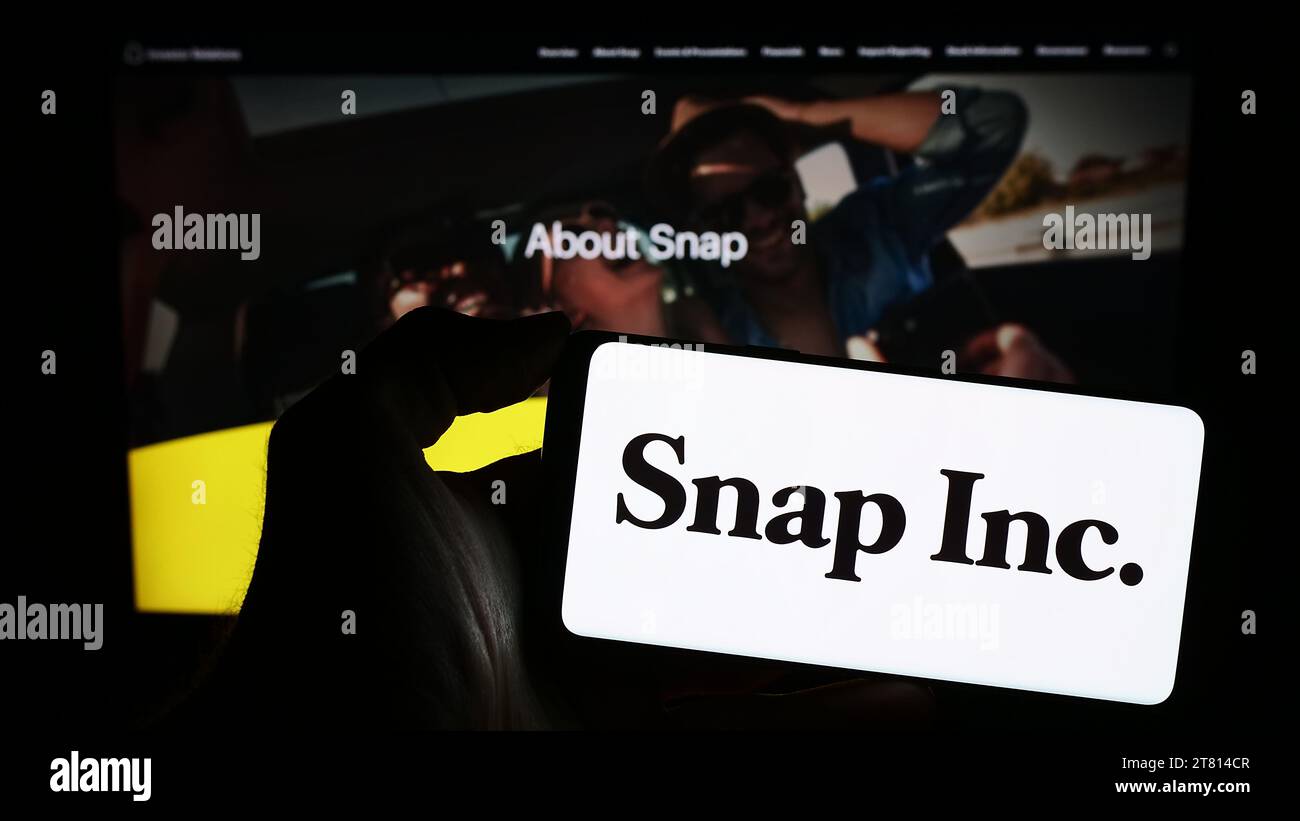 Personne détenant un smartphone avec le logo de la société américaine de médias sociaux Snap Inc. Devant le site Web. Concentrez-vous sur l'affichage du téléphone. Banque D'Images