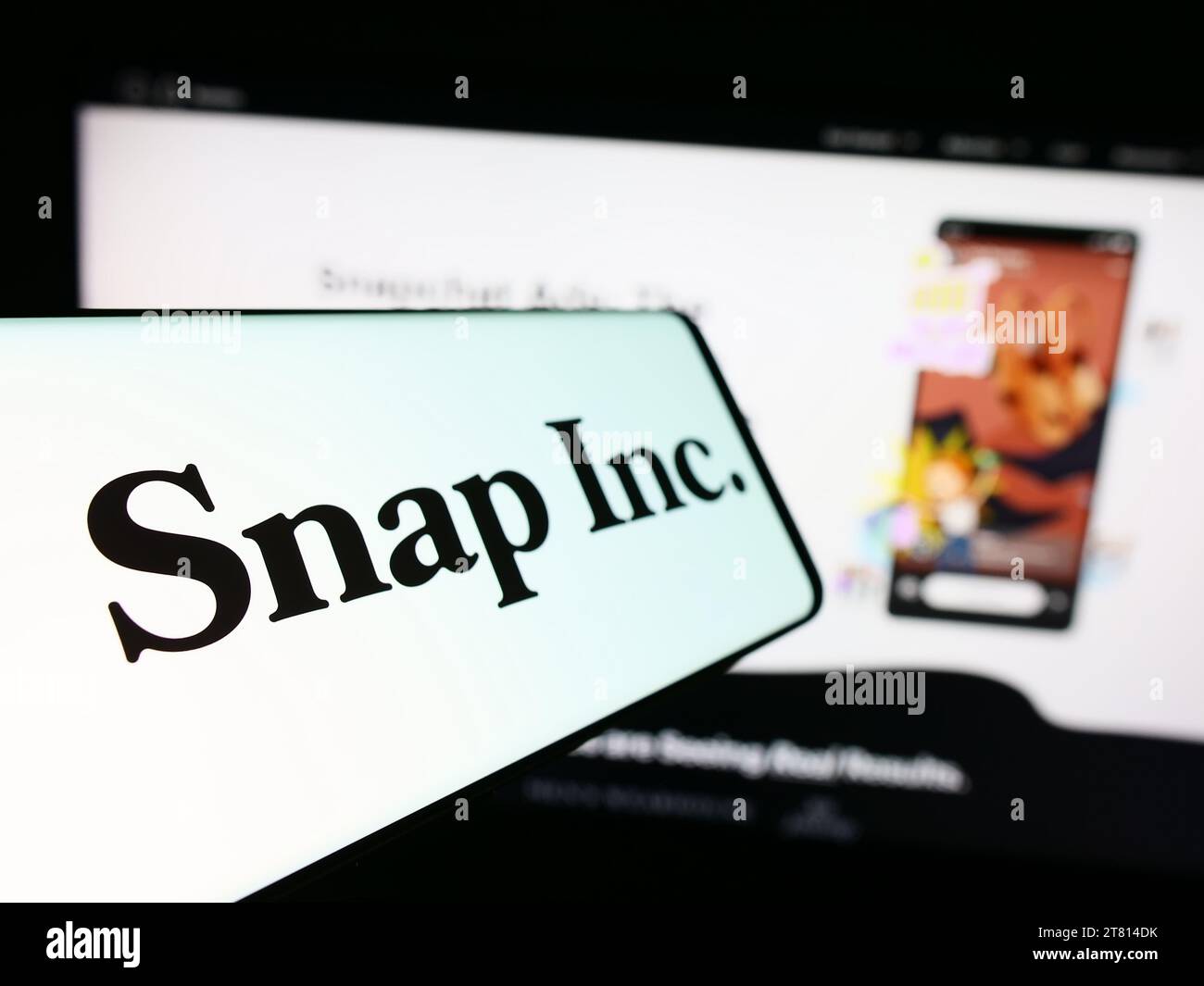Téléphone portable avec logo de la société américaine de médias sociaux Snap Inc. Devant le site Web de l'entreprise. Effectuez le focus sur la gauche de l'écran du téléphone. Banque D'Images