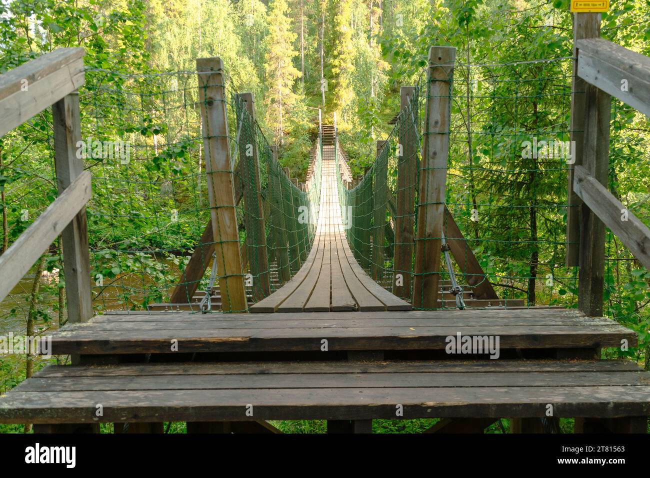 Une passerelle suspendue en bois traverse une rivière dans la forêt sur le sentier Bear, dans le nord de la Finlande Banque D'Images