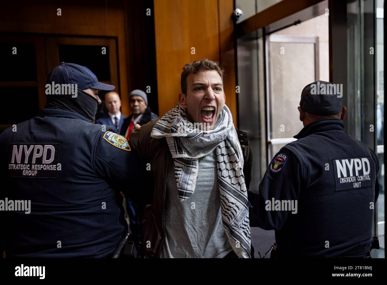 NEW YORK, NEW YORK - NOVEMBRE 17 : un manifestant pro-palestinien est arrêté et emmené par deux policiers New-yorkais dans le hall d'entrée du siège de News Corp lors d'une manifestation appelant à un cessez-le-feu à Gaza le 17 novembre 2023 à New York. Plusieurs manifestants sont entrés au siège de News Corp à Manhattan aujourd'hui dans le cadre d'une journée mondiale d'action en faveur de la Palestine (photo de Michael Nigro/Sipa USA) crédit : SIPA US/Alamy Live News Banque D'Images