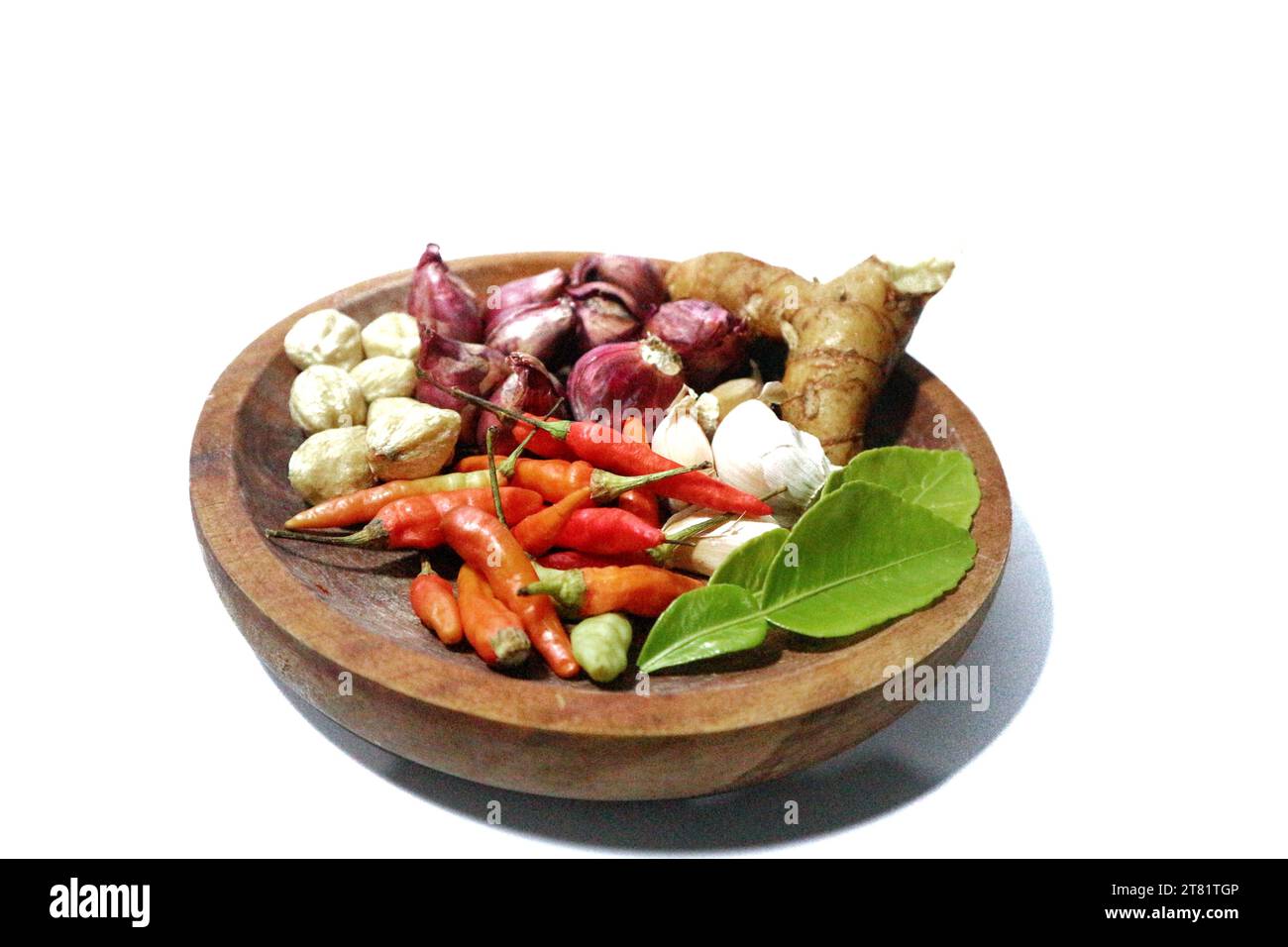 différents types d'épices de cuisine sont placés sur une plaque en bois, sur un fond blanc Banque D'Images