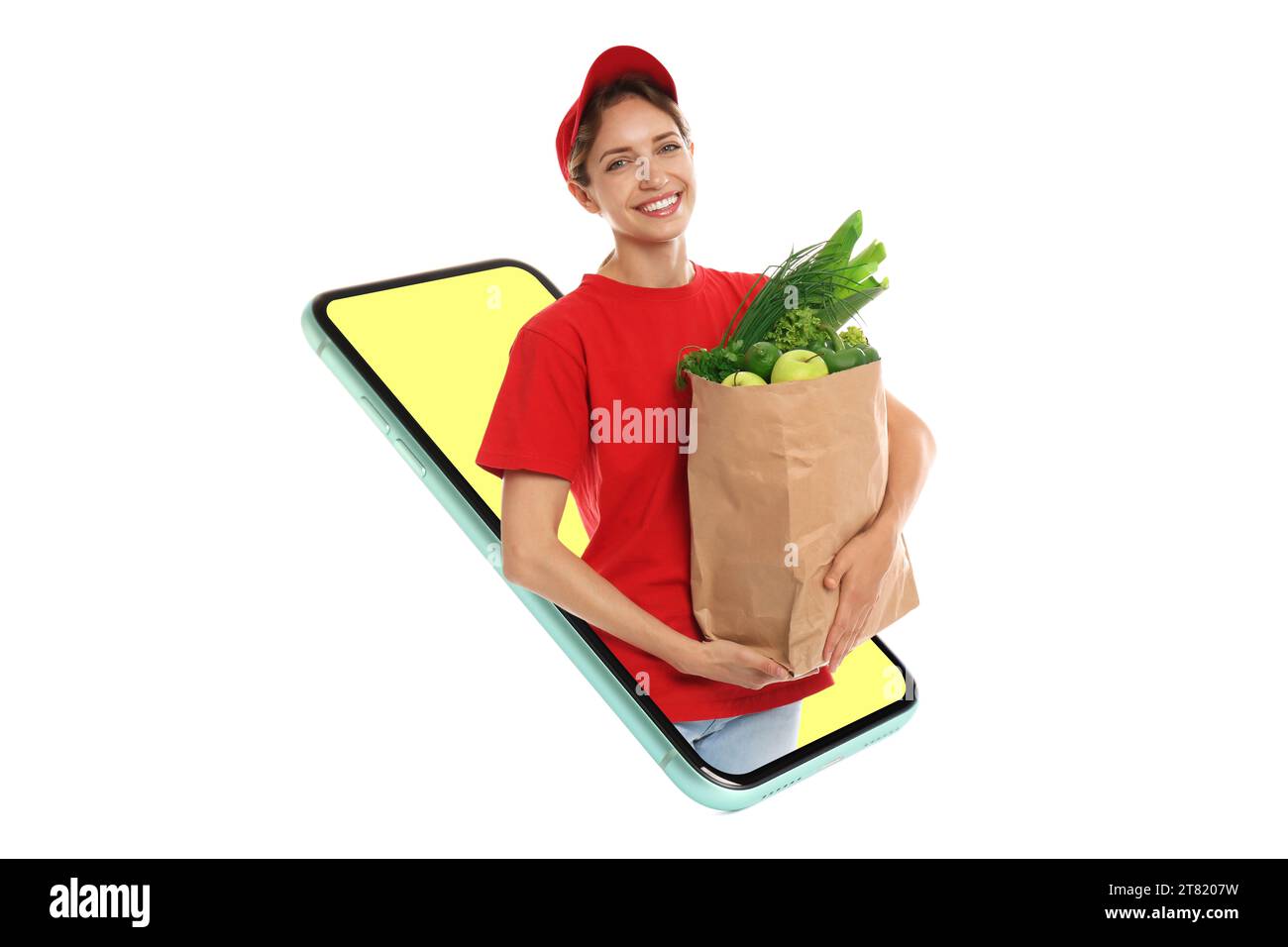 Épicerie via Internet. Femme de livraison avec sac plein de produits regardant énorme smartphone sur fond blanc Banque D'Images