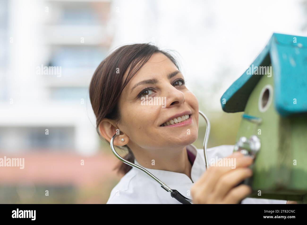 Médecin examine l'état de la boîte de nidification avec un stéthoscope protection de l'environnement Banque D'Images