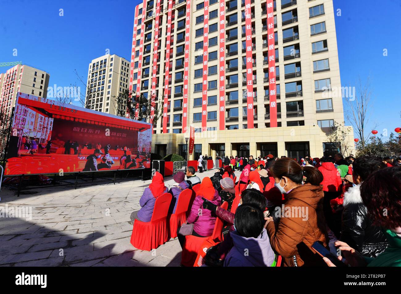 QINGDAO, CHINE - 18 NOVEMBRE 2023 - les résidents regardent le processus de distribution de logements devant un grand écran sur le site de distribution de logements de Xia Banque D'Images