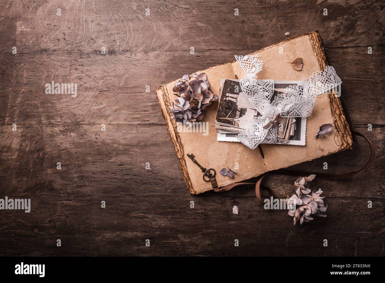 Souvenirs, photos de famille antiques et anciennes avec des fleurs séchées dans un style vintage sur une table en bois Banque D'Images