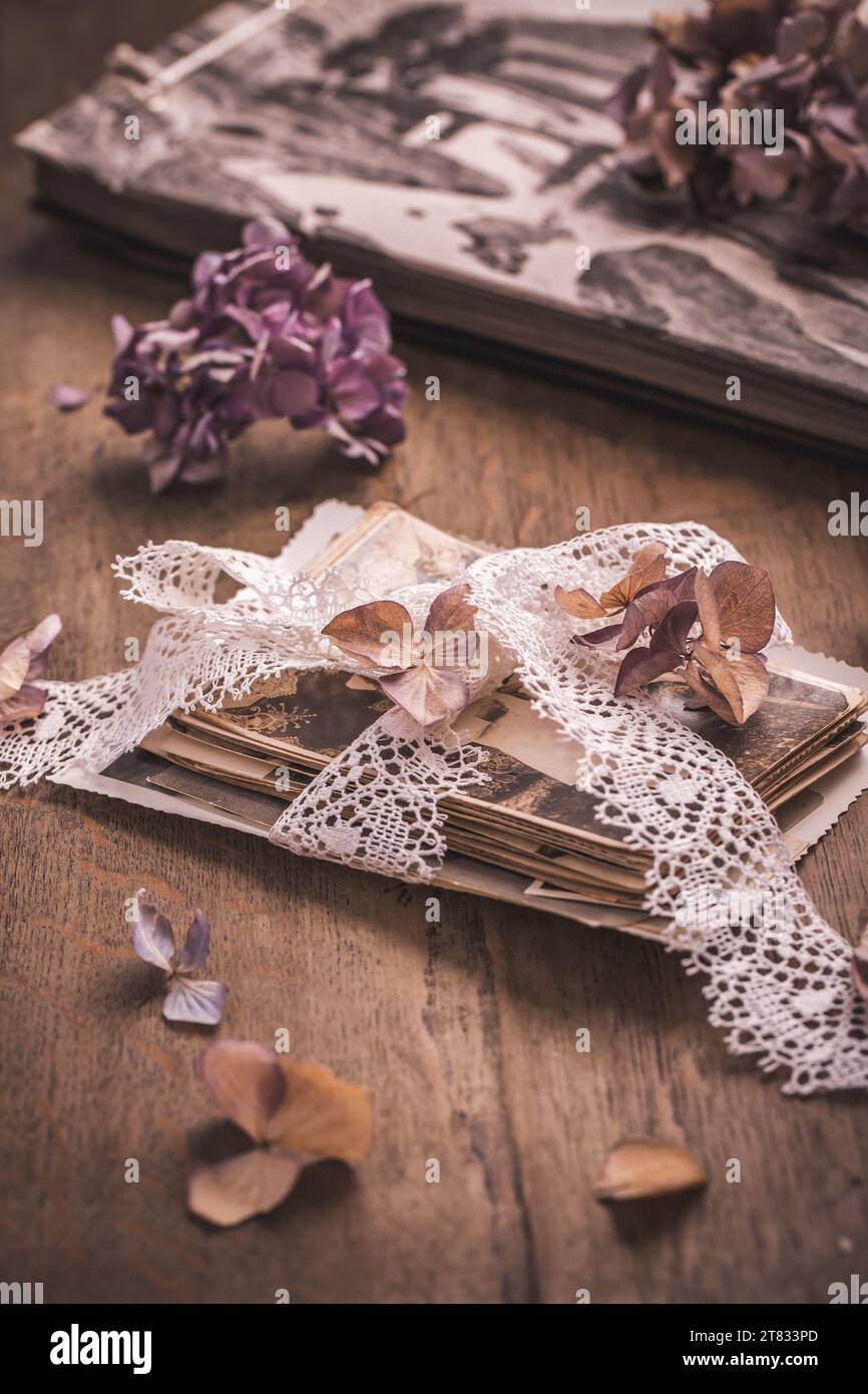 Souvenirs, photos de famille antiques et anciennes avec des fleurs séchées dans un style vintage sur une table en bois Banque D'Images