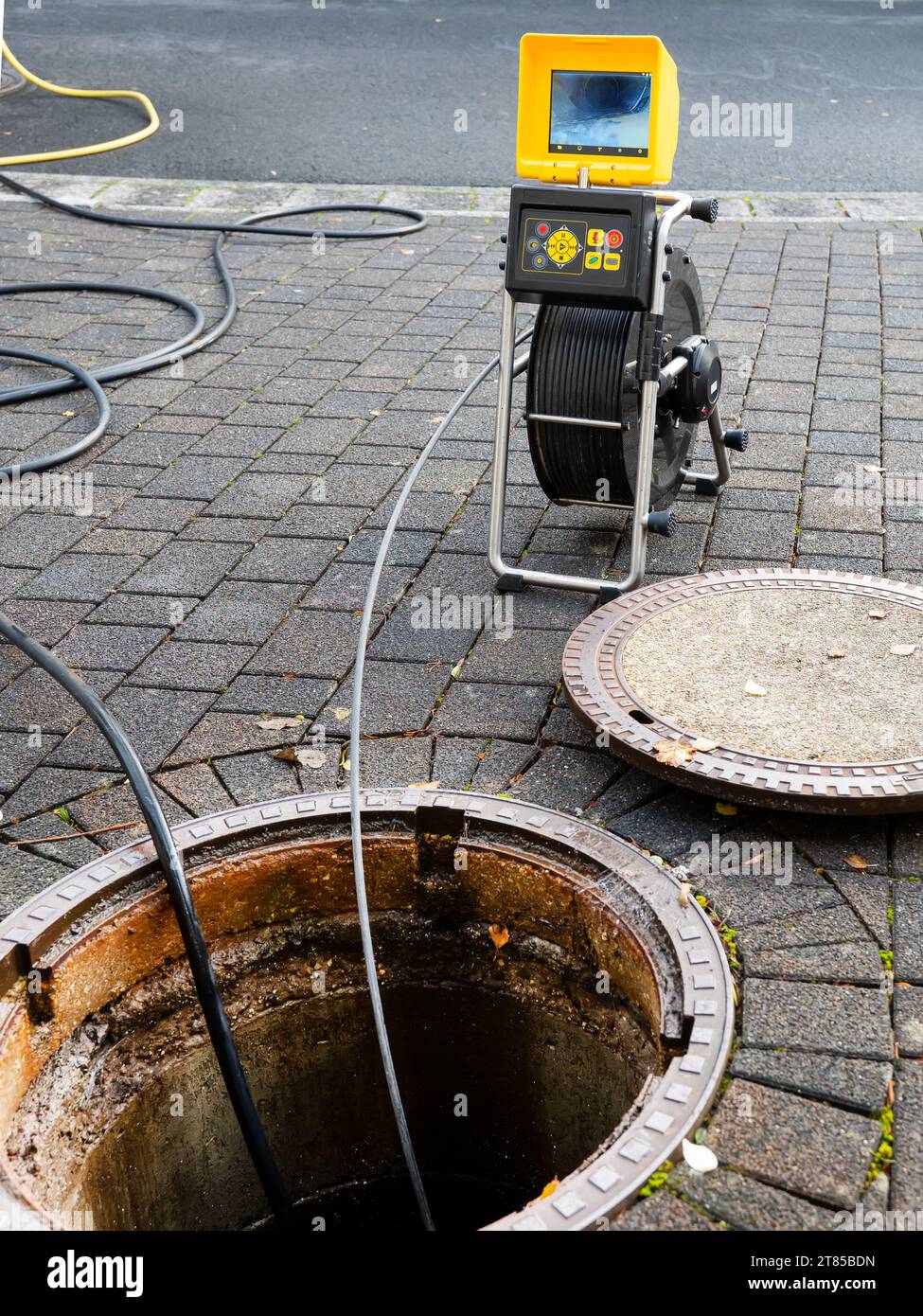 Une entreprise de nettoyage de drain vérifie un drain bouché avec une caméra avant de le rincer Banque D'Images