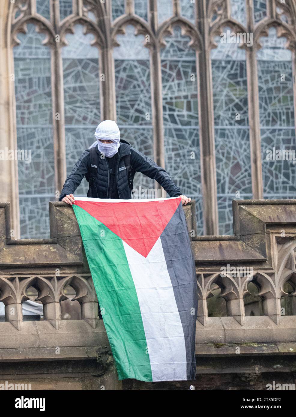 Drapeaux palestiniens brandis depuis la balustrade de la cathédrale lors d'une manifestation palestinienne dans le centre de Manchester. ROYAUME-UNI. Plus d'un millier de manifestants se sont rassemblés à Whitworth Park pour réclamer un cessez-le-feu. Ils ont ensuite marché devant l'université de Manchester le long d'Oxford Rd jusqu'au centre-ville. La police gardait des points de vente qui, selon les manifestants, avaient des liens avec Israël, y compris McDonalds et Fisher Geram. La marche s'est terminée à la cathédrale de Manchester où certains manifestants ont monté la balustrade de la cathédrale et brandi des drapeaux. Manchester UK. Photo : garyroberts/worldwidefeatures.com Banque D'Images